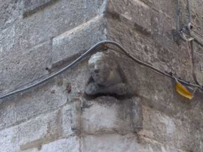 Bene, se si alza la testa si noter� che appena sopra il portone d�ingresso, sul cantone che affaccia su vico Fortunato, si trova un simpatico mascherone a forma di testa umana che mostra la lingua in segno di dileggio...